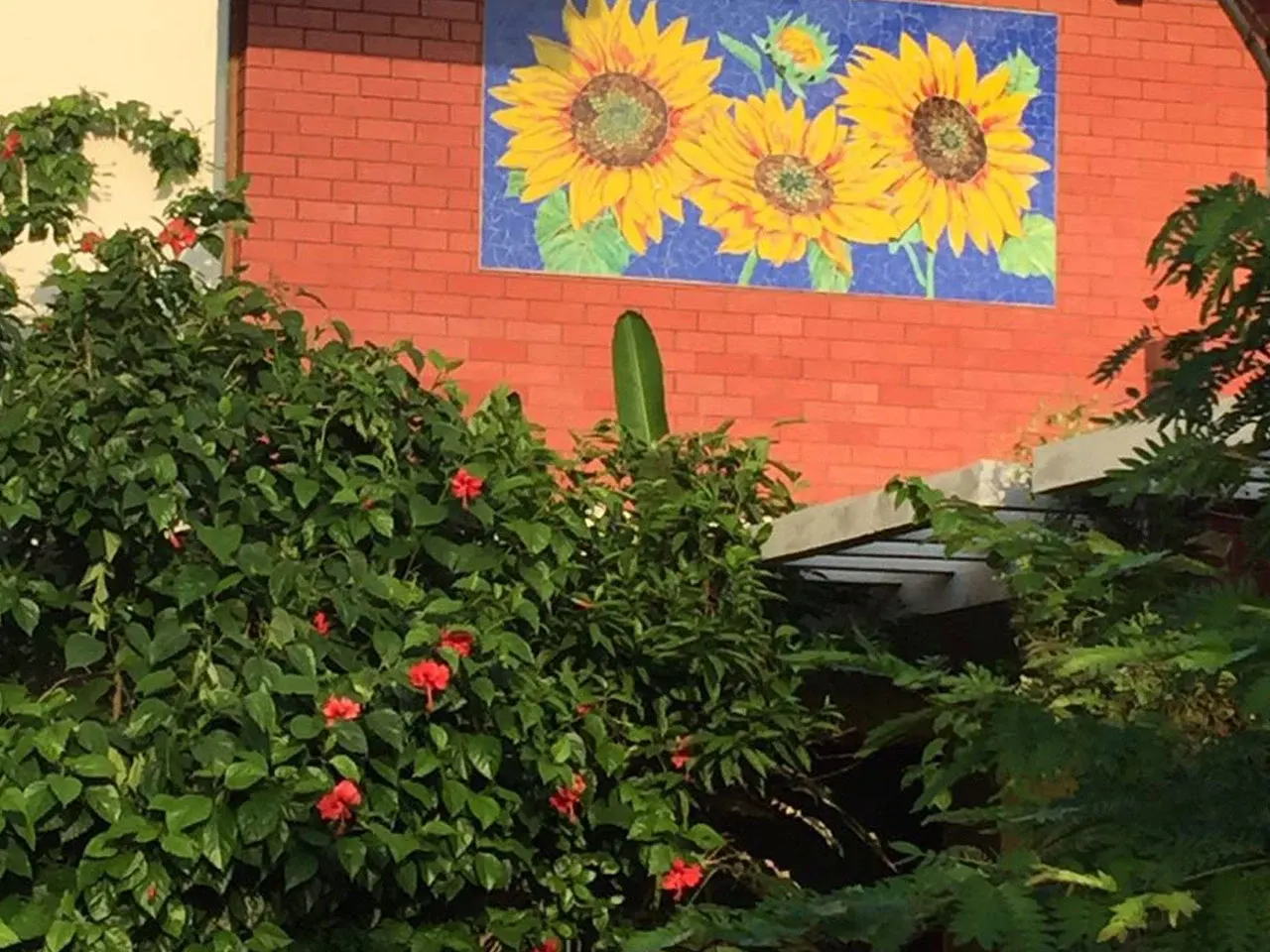 Outdoor sunflower mosaic panel at the entrance of an Ahmedabad residence